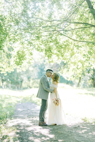 抱き合ったりキスしたり公園での結婚式 自然の中の美術のスタイルで写真撮影 — ストック写真