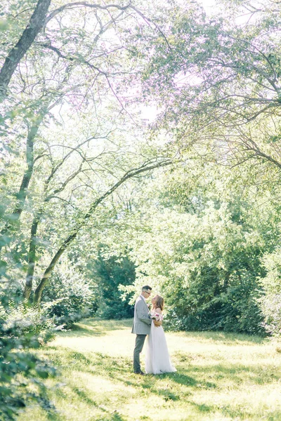 抱き合ったりキスしたり公園での結婚式 自然の中の美術のスタイルで写真撮影 — ストック写真