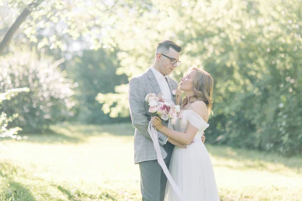 抱き合ったりキスしたり公園での結婚式 自然の中の美術のスタイルで写真撮影 — ストック写真