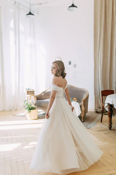 Fees in the interior Studio in the European style. The bride in a white wedding dress.