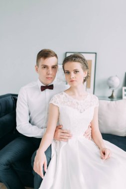 Güzel çift stüdyoda oturan ve sarılma. Avrupa tarzı güzel sanatlar düğün.