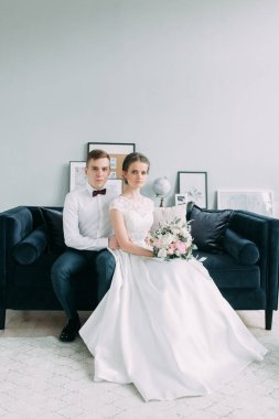 Güzel çift stüdyoda oturan ve sarılma. Avrupa tarzı güzel sanatlar düğün.