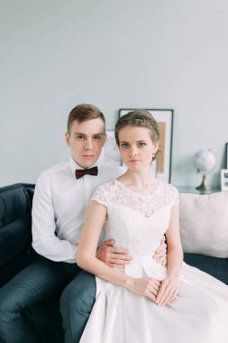 Güzel çift stüdyoda oturan ve sarılma. Avrupa tarzı güzel sanatlar düğün.