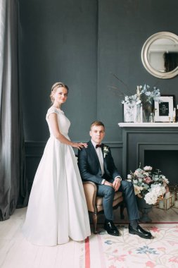 Güzel çift stüdyoda oturan ve sarılma. Avrupa tarzı güzel sanatlar düğün.