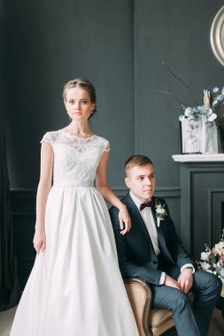 Güzel çift stüdyoda oturan ve sarılma. Avrupa tarzı güzel sanatlar düğün.