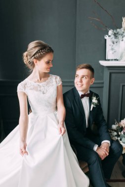 Güzel çift stüdyoda oturan ve sarılma. Avrupa tarzı güzel sanatlar düğün.