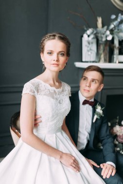 Güzel çift stüdyoda oturan ve sarılma. Avrupa tarzı güzel sanatlar düğün.