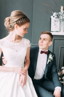 Güzel çift stüdyoda oturan ve sarılma. Avrupa tarzı güzel sanatlar düğün.