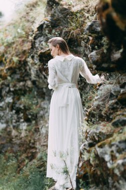 Güzel bir panoramik yerde Sabah gelin. Boudoir elbise ve kayalıklar kız.