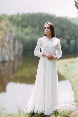 Güzel bir panoramik yerde Sabah gelin. Boudoir elbise ve kayalıklar kız.