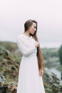 Güzel bir panoramik yerde Sabah gelin. Boudoir elbise ve kayalıklar kız.