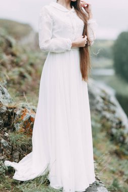 Güzel bir panoramik yerde Sabah gelin. Boudoir elbise ve kayalıklar kız.