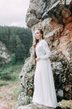 Güzel bir panoramik yerde Sabah gelin. Boudoir elbise ve kayalıklar kız.