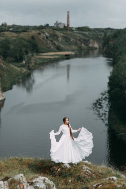 Güzel bir panoramik yerde Sabah gelin. Boudoir elbise ve kayalıklar kız.