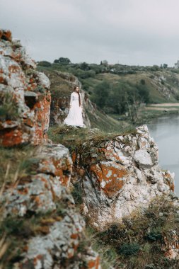 Güzel bir panoramik yerde Sabah gelin. Boudoir elbise ve kayalıklar kız.