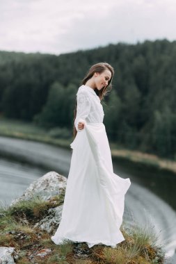 Güzel bir panoramik yerde Sabah gelin. Boudoir elbise ve kayalıklar kız.