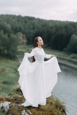 Güzel bir panoramik yerde Sabah gelin. Boudoir elbise ve kayalıklar kız.