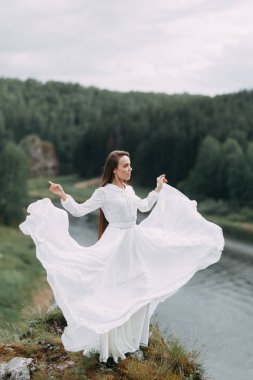 Güzel bir panoramik yerde Sabah gelin. Boudoir elbise ve kayalıklar kız.