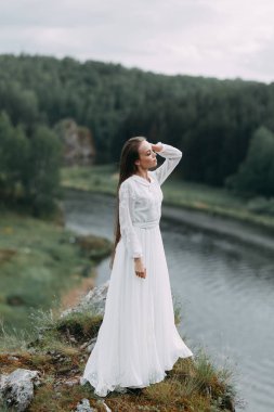 Güzel bir panoramik yerde Sabah gelin. Boudoir elbise ve kayalıklar kız.