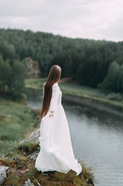 Güzel bir panoramik yerde Sabah gelin. Boudoir elbise ve kayalıklar kız.