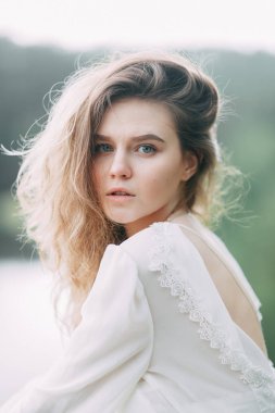 Beyaz elbiseli doğada Boudoir sabah gelin. Serisi kayalıklarla ve nehir üzerinde düğün virajlı.