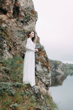 Beyaz elbiseli doğada Boudoir sabah gelin. Serisi kayalıklarla ve nehir üzerinde düğün virajlı.