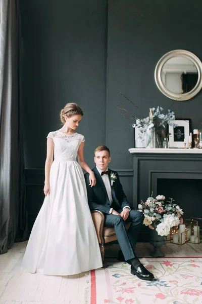 Güzel çift stüdyoda oturan ve sarılma. Avrupa tarzı güzel sanatlar düğün.