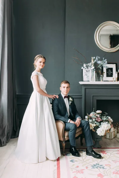 Güzel çift stüdyoda oturan ve sarılma. Avrupa tarzı güzel sanatlar düğün.