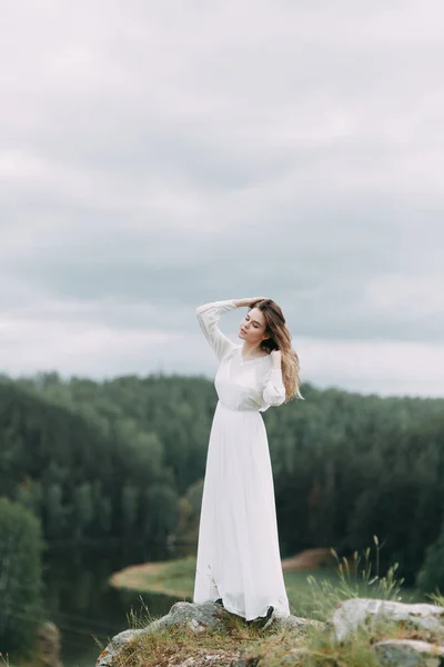 自然の中で白いドレス私室朝花嫁 結婚式の崖と川のシリーズを曲げる — ストック写真