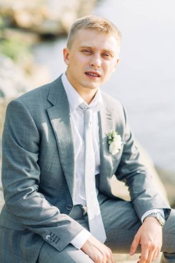 Doğada su damat. Toplantıda genç bir adamın iskelede günbatımı.