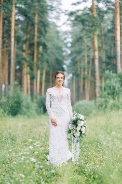 İçinde doğa ile bir buket düğün elbise gelin. Boudoir Fotoğraf çekimi çam lemu güzel sanatlar tarzı içinde.