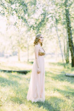 Aerial photo shoot at sunset in the forest. Girl in a flying dress in the style of fine art.