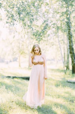 Aerial photo shoot at sunset in the forest. Girl in a flying dress in the style of fine art.