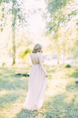 Aerial photo shoot at sunset in the forest. Girl in a flying dress in the style of fine art.