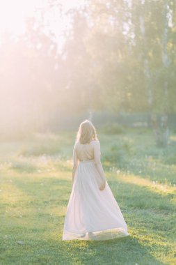Aerial photo shoot at sunset in the forest. Girl in a flying dress in the style of fine art.