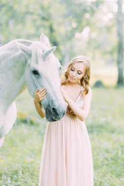 Bir at ile ormanda gün batımında hava fotoğraf çekimi. Tek boynuzlu atlı uçan elbiseli bir kız..