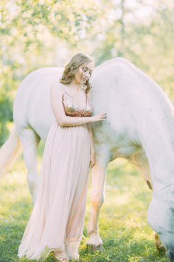 Bir at ile ormanda gün batımında hava fotoğraf çekimi. Tek boynuzlu atlı uçan elbiseli bir kız..