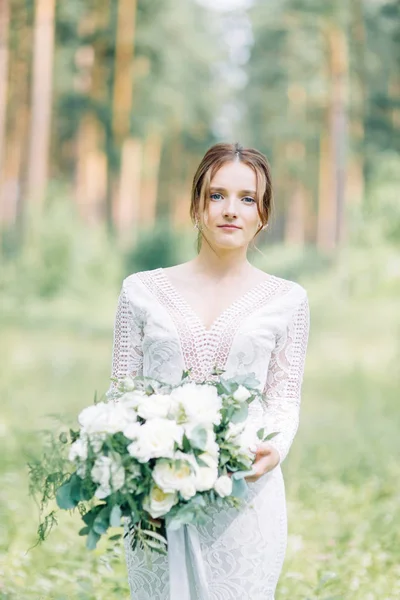 花束を持つ自然の中のウェディング ドレスの花嫁 美術のスタイルで松 Lemu で私室の写真撮影します — ストック写真