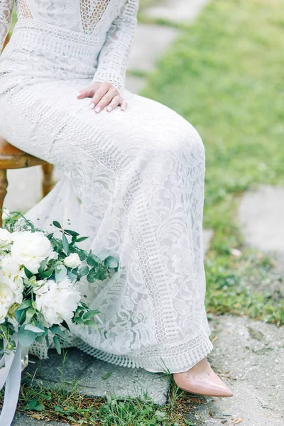 The bride in a wedding dress in nature with a bouquet. Boudoir photo shoot in pine lemu in the style of fine art.