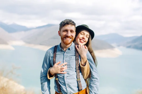 A beautiful couple travels in the mountains of Georgia. Lovestory in nature with a lake.