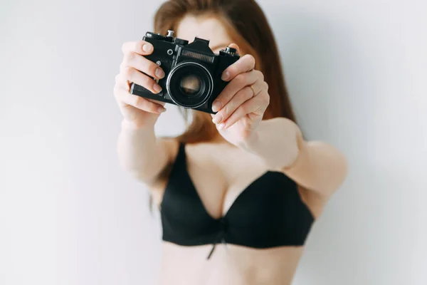 Girl in lingerie with a camera in his hands. Blogger on the cover of an advertising poster.