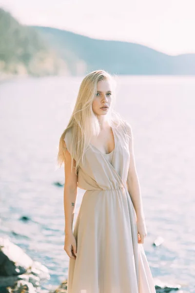 女孩在湖面上穿着闺房礼服 站着微笑着 与自然团结 俄罗斯的晨妇 美丽的眼睛和模型外观 — 图库照片