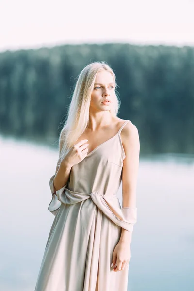 日落时穿着闺房礼服的女孩在湖边 费用新娘的性质 美丽的模型 长头发的俄罗斯女孩 — 图库照片