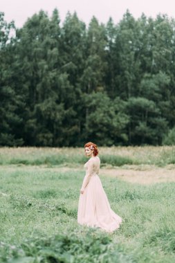 Uzun otların dolu bir alanda gelin. Avrupa tarzı doğada düğün fotoğraf çekimi.
