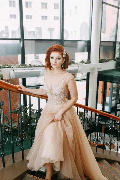 The bride is in an expensive hotel on the stairs. Wedding photo shoot in a beautiful dress.