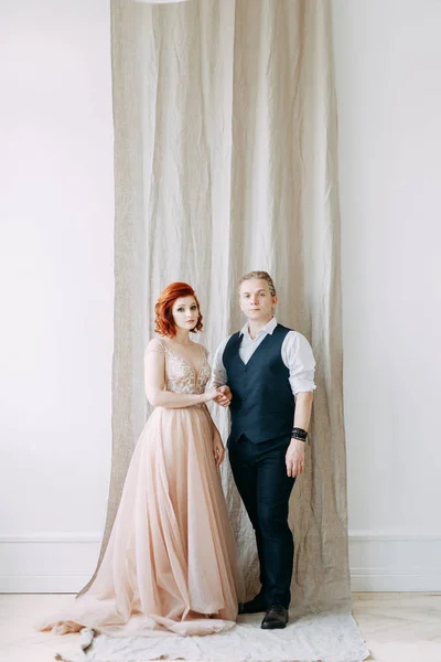 Meeting the newlyweds in the Studio and hotel. Bride and groom with a bouquet.