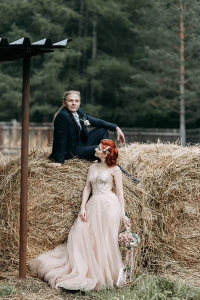 干し草と馬小屋で結婚式の写真撮影 美しいカップルは ヨーロッパの結婚式 — ストック写真