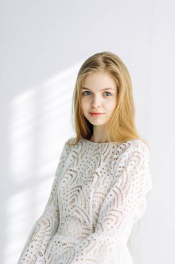 Güzel gelin beyaz Studio bir sandalyede oturuyor. Minimalist Avrupa tarzında düğün.