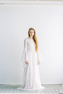 Güzel gelin beyaz minimalist zemin üzerinde. Güzel Sanatlar düğün hazırlıkları.