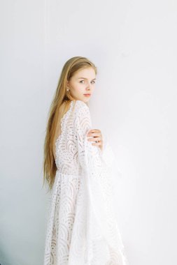 Güzel gelin beyaz minimalist zemin üzerinde. Güzel Sanatlar düğün hazırlıkları.